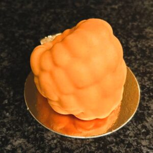 Hjortron- Trompe l'oeil fruktbakelse. Fylld med vaniljmousse och hjortronkompott, doppad i färgad vit choklad.