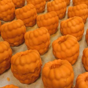 Hjortron- Trompe l'oeil fruktbakelse. Fylld med vaniljmousse och hjortronkompott, doppad i färgad vit choklad.