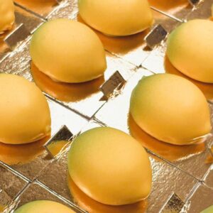 Minicitron- Trompe l'oeil fruktbakelse. Fylld med fräsch citronmousse och en kärna av citroncurd,  sedan doppad i färgad vit choklad.